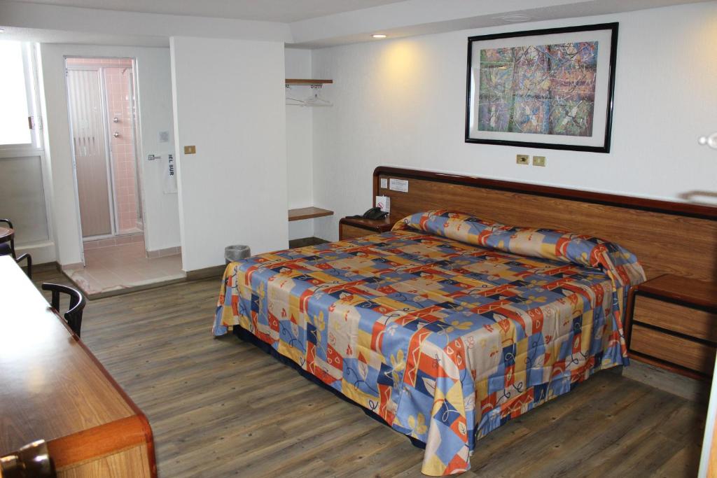 ein Hotelzimmer mit einem Bett und einem Tisch in der Unterkunft Hotel del Sur in Mexiko-Stadt