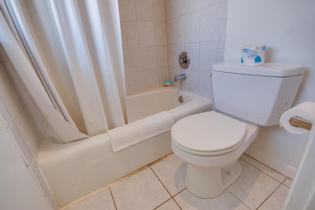 a bathroom with a toilet and a bath tub with a shower curtain at Sahara Motel in Ocean City