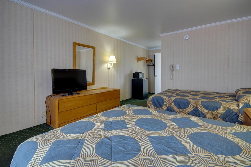 a hotel room with two beds and a flat screen tv at Sahara Motel in Ocean City