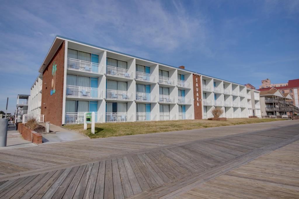 a large apartment building on the beach with a boardwalk at Sahara Motel in Ocean City