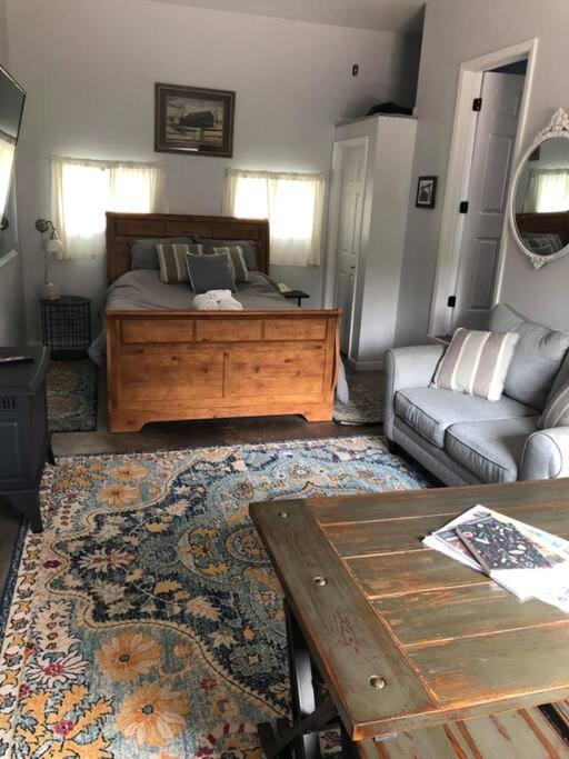 a bedroom with a bed and a couch and a table at Downtown Yellowstone Bungalow in Livingston