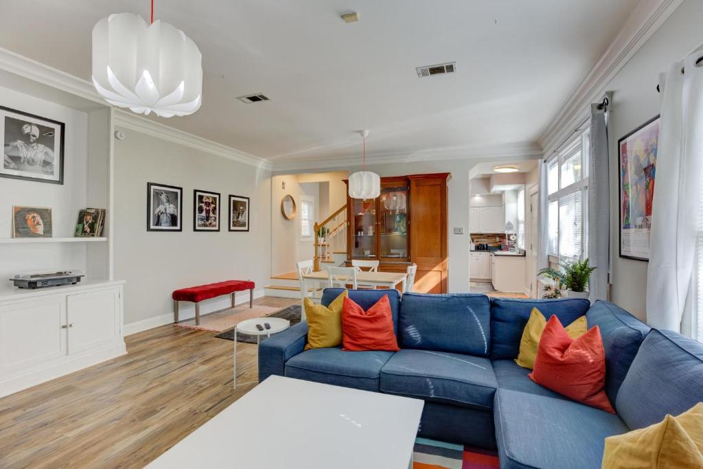 a living room with a blue couch and orange pillows at Hip and Spacious Midtown Cottage near Beale Street in Memphis