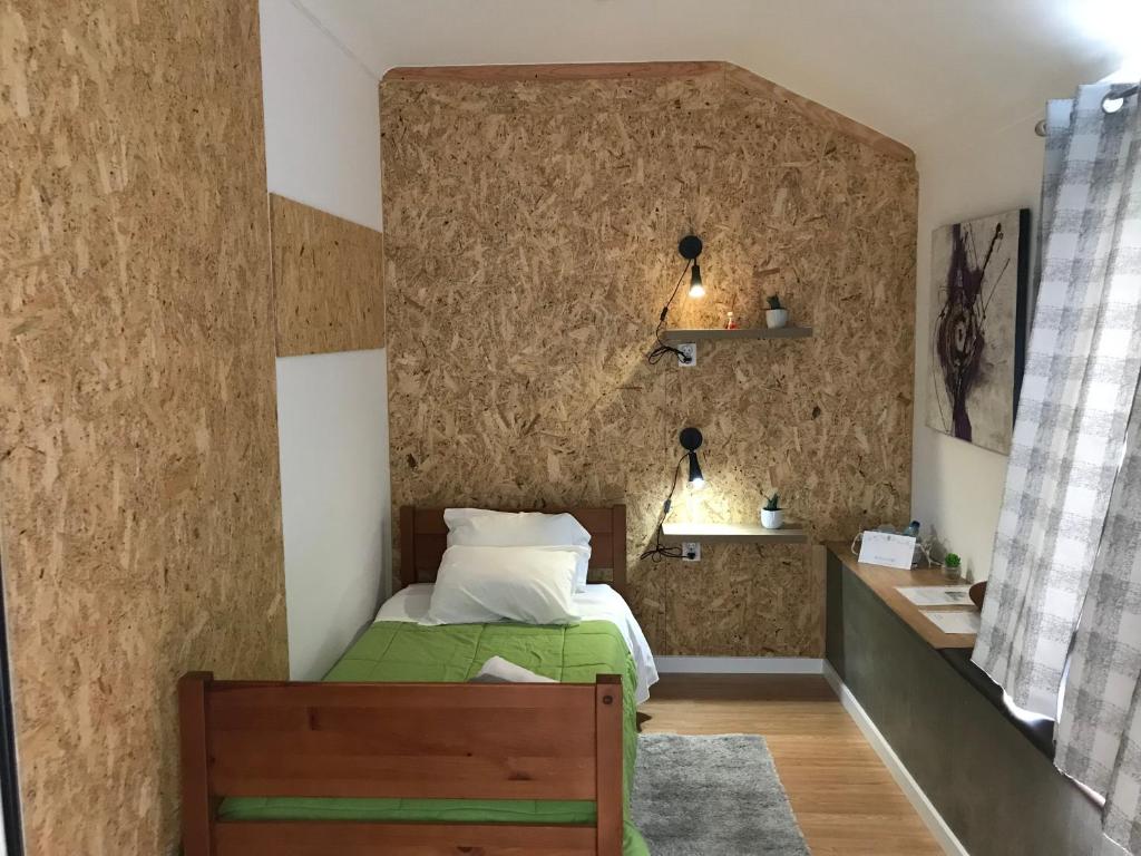 a bedroom with a bed and a wall covered in wallpaper at Afternoon Desire in Ponta Delgada