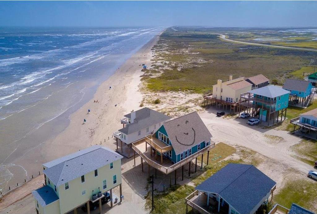 an aerial view of a beach with houses and the ocean at Martinis & Bikinis, a beach front house with toes in the sand drink in the hand. in Freeport