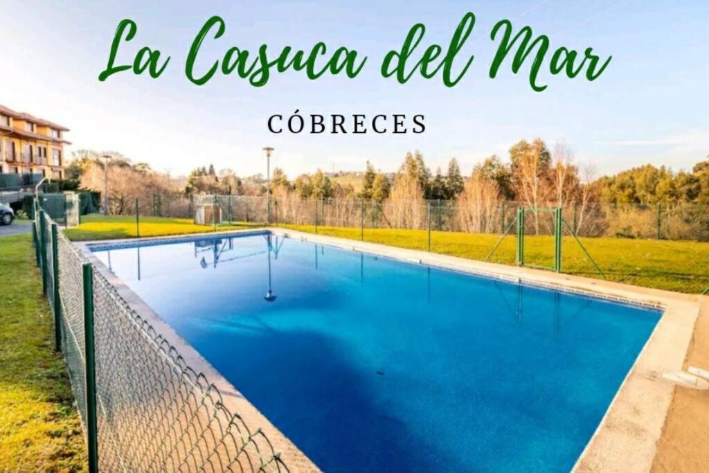 una piscina azul con las palabras la casa del maclez en Te encantará este duplex en Cóbreces, en Cóbreces