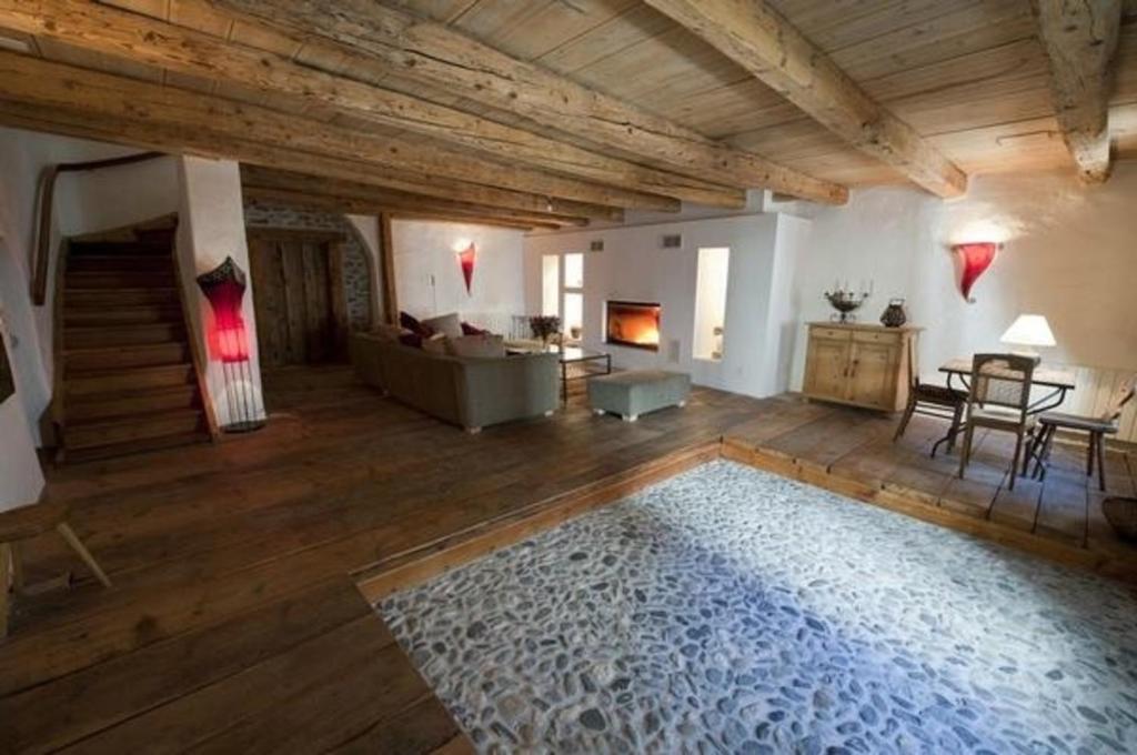 a large living room with a couch and a fireplace at Chasa Florinja in Scuol