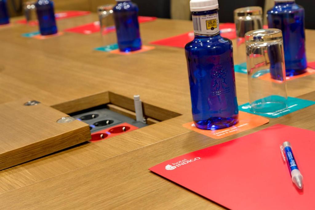 una mesa de madera con una botella azul encima en Hotel Indigo Madrid - Gran Via, an IHG Hotel en Madrid