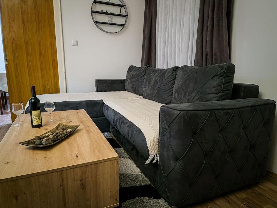 a living room with a couch and a table with wine glasses at Olive's apartment in Podgorica