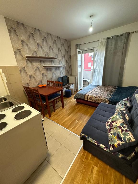 a living room with a bed a couch and a table at Ania apartment in Podgorica