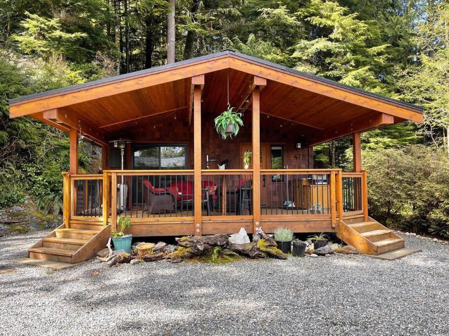 Cabaña de madera con porche cubierto en Cozy Corner Cottage, en Port Renfrew