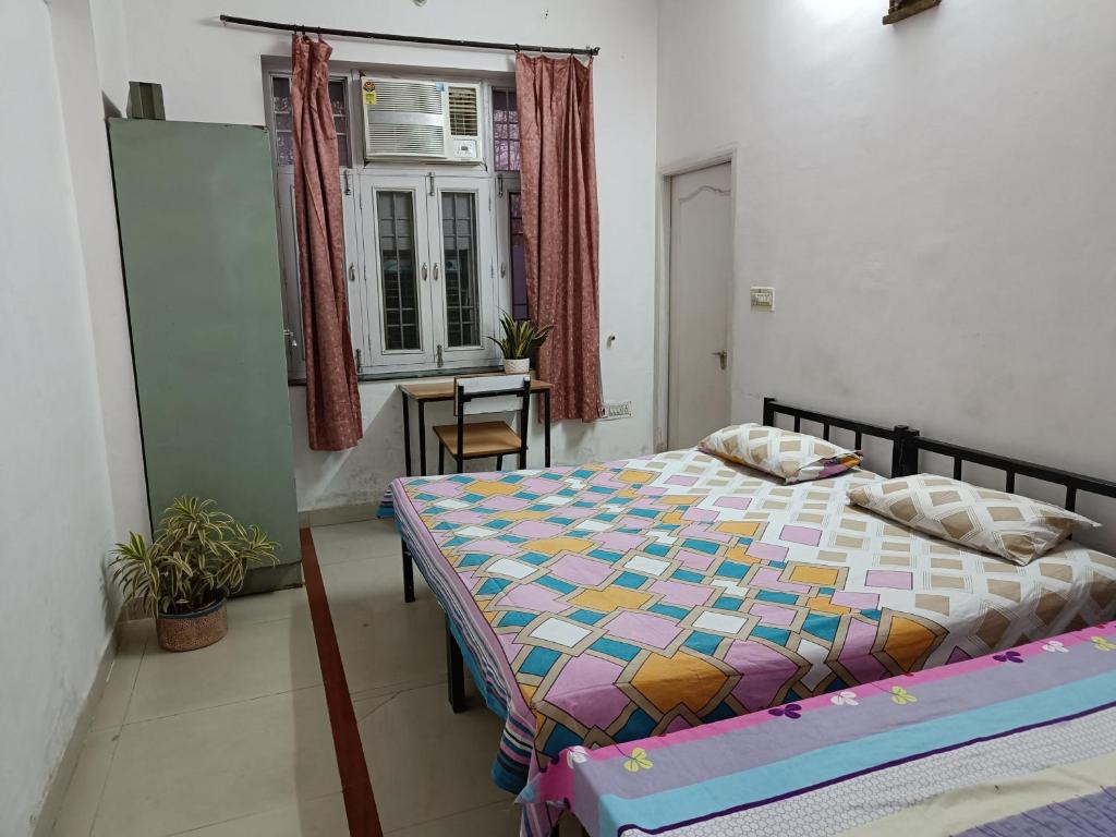 a bedroom with a bed in a room with a window at House No 87A in Jaipur