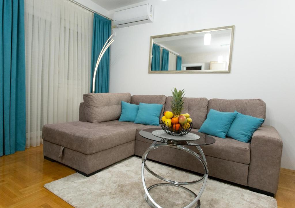 a living room with a couch and a table with fruit on it at Apartman SUNSET in Sremska Mitrovica