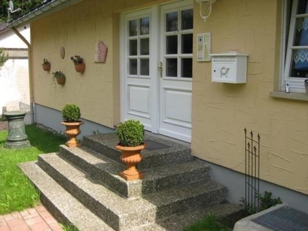 una casa con escaleras que conducen a una puerta blanca en Wohnung in Schönwald Im Schwarzwald mit Garten und Terrasse, en Schönwald