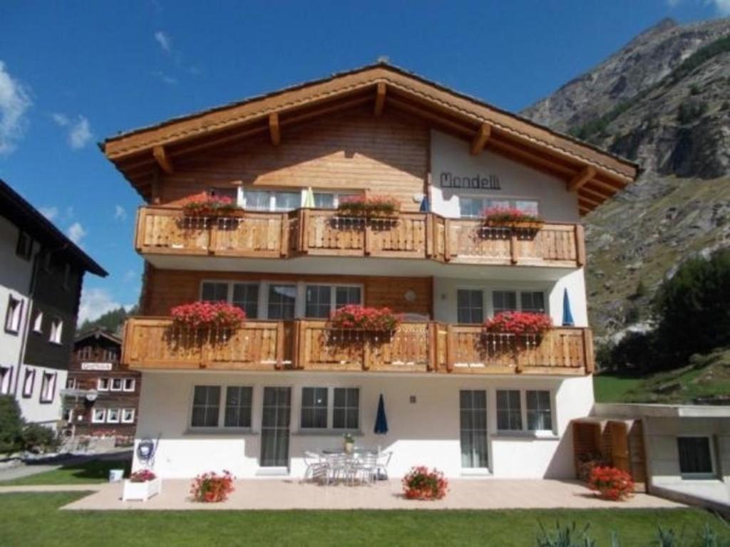 a building with a balcony with flowers on it at Topwohnung für 2 - 3 Personen mit einem getrennten Schlafzimmer in Saas-Almagell