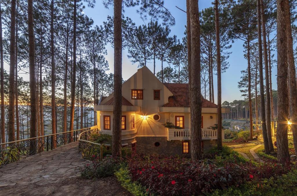 a house in the woods with the lights on at Omirita Resort Dalat in Da Lat