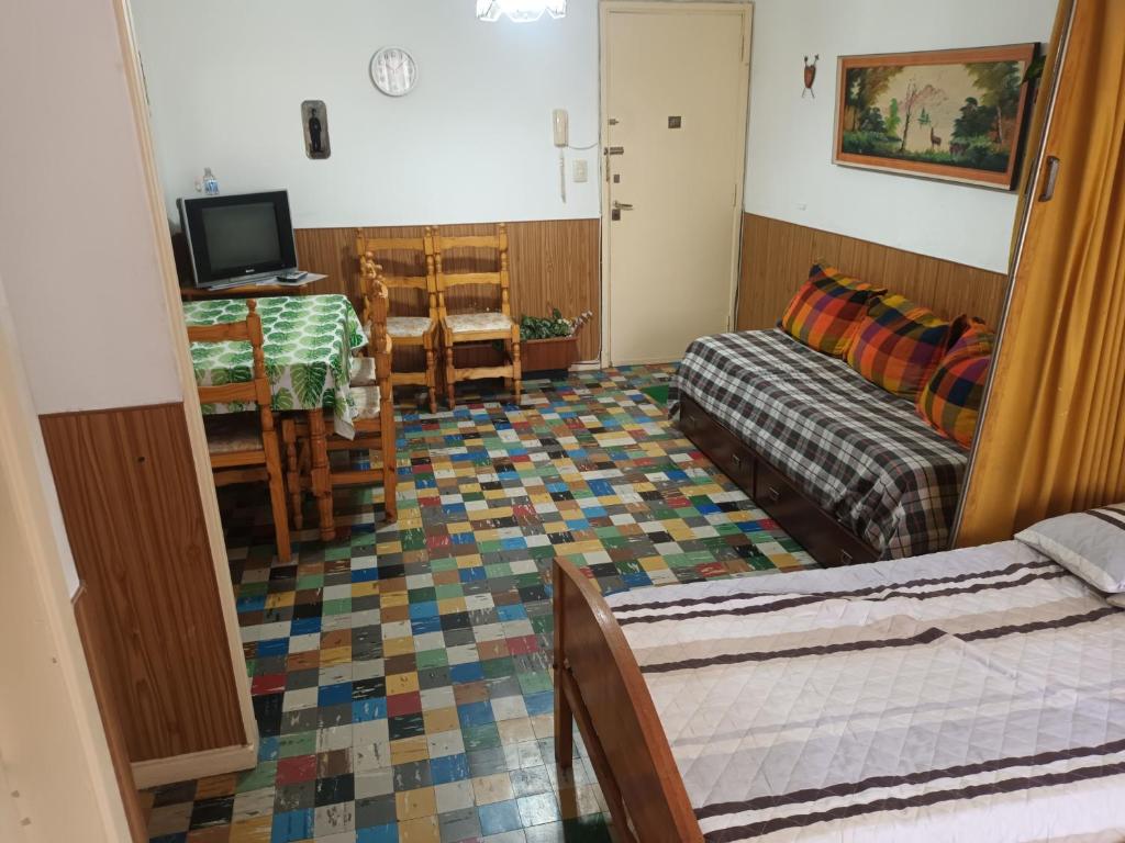 Habitación con cama, mesa y sofá en Monoambiente sencillo a 2 de la peatonal y 2 del mar en Mar del Plata