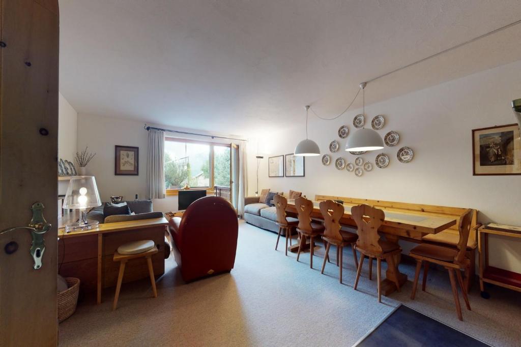 a dining room with a long table and chairs at Apartment Pradè in Samedan