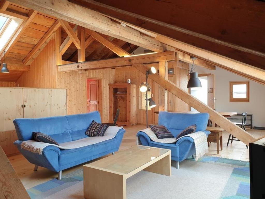 a living room with two blue couches and a table at Barba Peder - BioBergün in Bergün