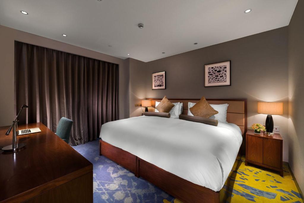 Postel nebo postele na pokoji v ubytování Oakwood Hotel & Residence Suzhou