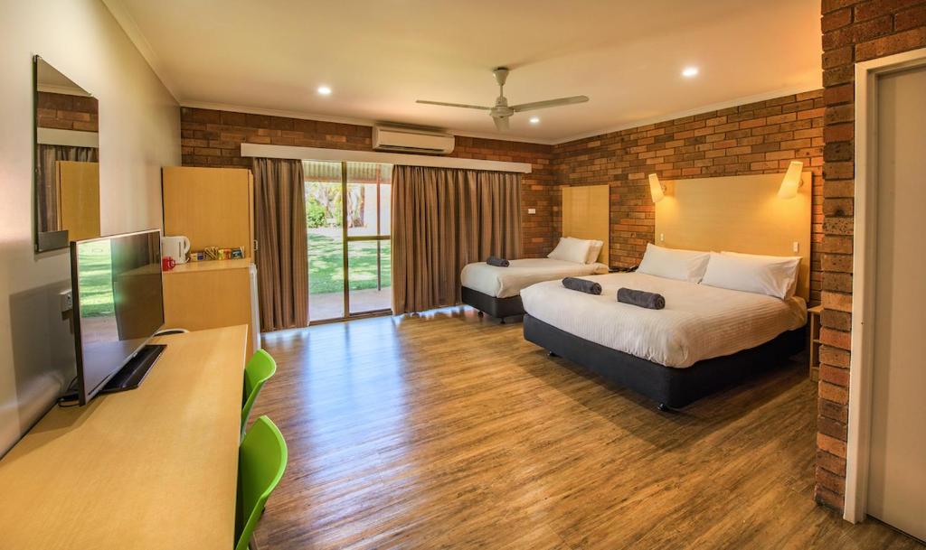 a hotel room with two beds and a flat screen tv at Contour Hotel Katherine in Katherine