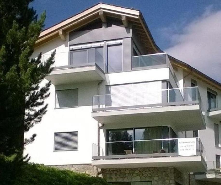 biały budynek z dużym balkonem w obiekcie Chavallera Casa Torri w Sankt Moritz