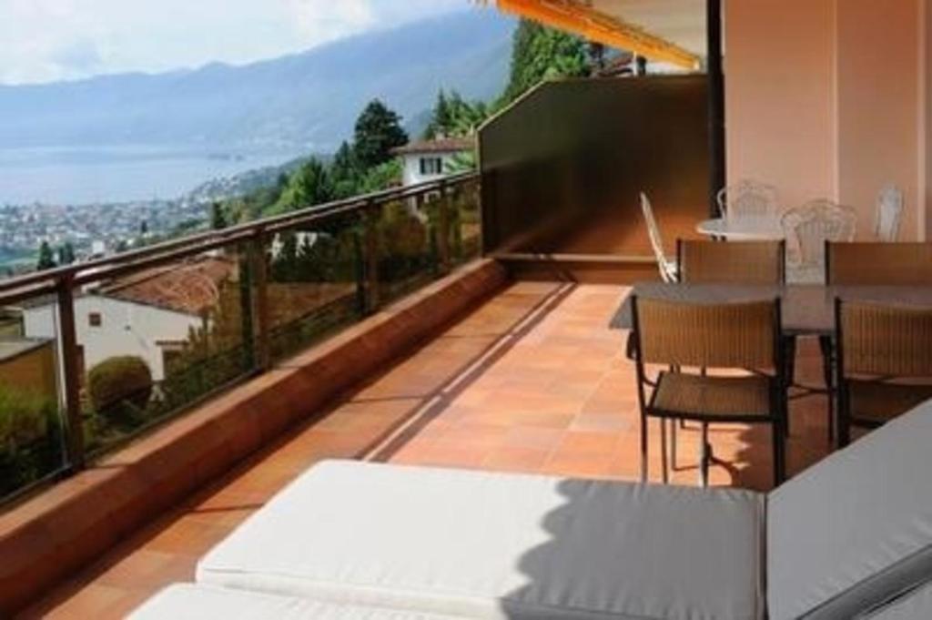 a balcony with a table and chairs and a view at Casa Panoramica Apt 5 in Orselina