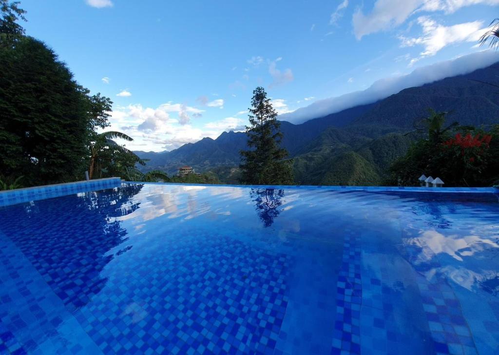 a swimming pool with a view of the mountains at Catcat Garden House in Sapa