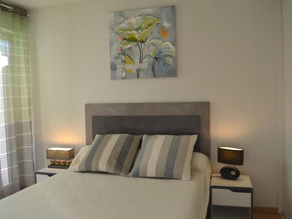 a bedroom with a white bed with two nightstands and two lamps at Appartement Capbreton, 2 pièces, 4 personnes - FR-1-239-872 in Capbreton