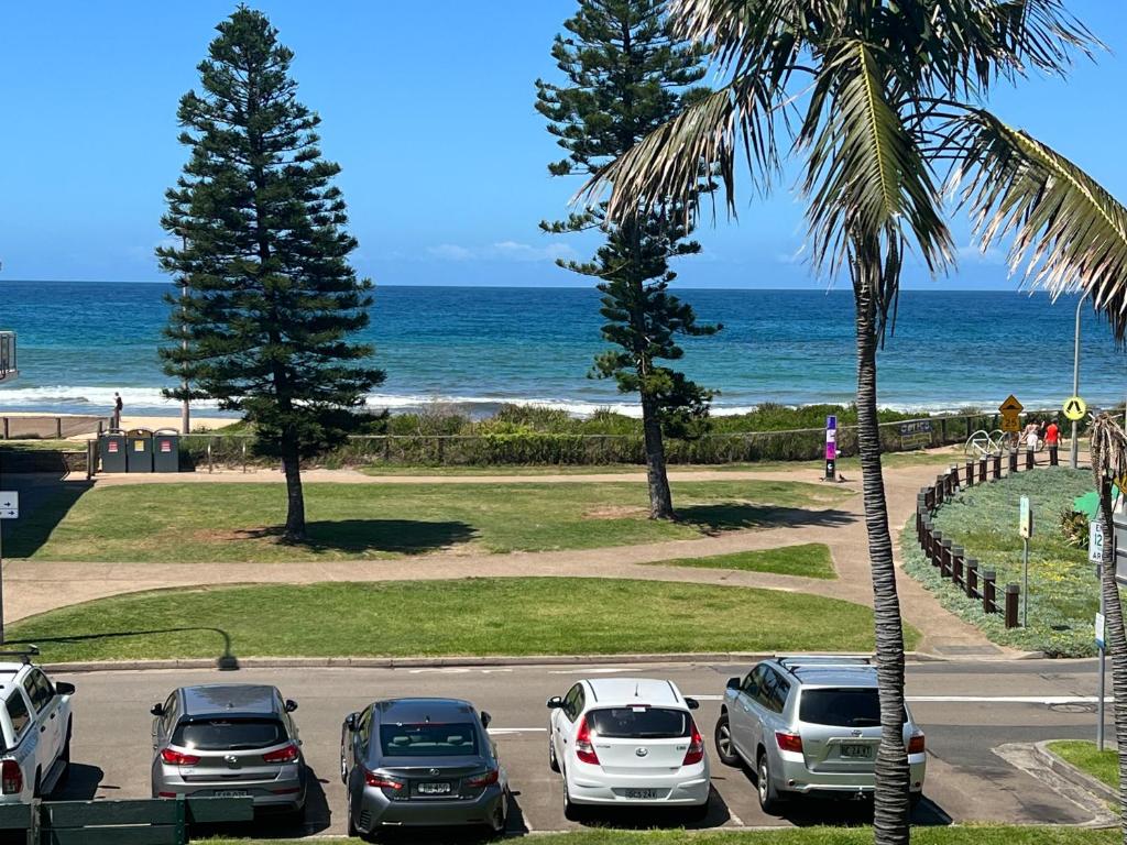 a parking lot with cars parked next to the beach at Dee Why Beach - Studio 29 Surfrider in Deewhy