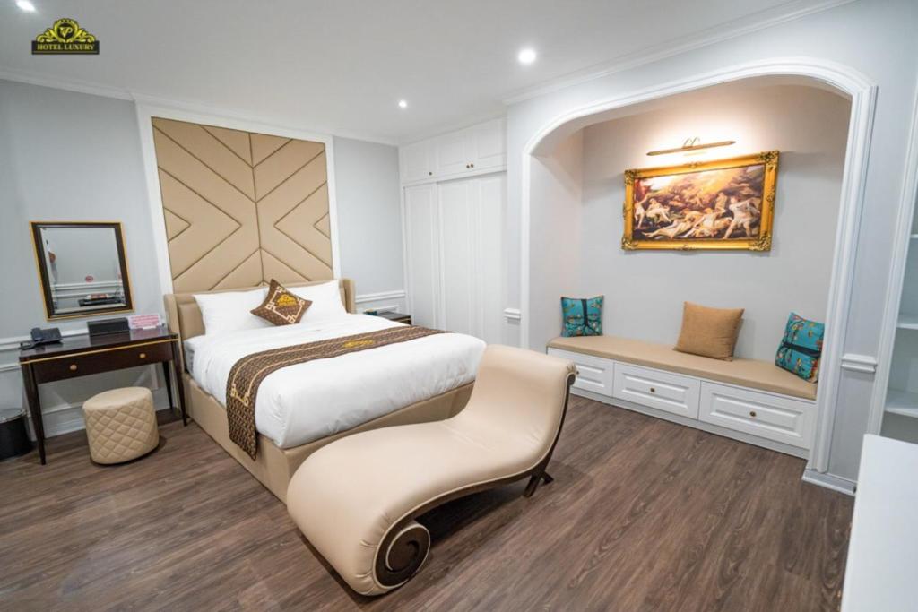 Schlafzimmer mit einem Bett, einem Schreibtisch und einem Stuhl in der Unterkunft VP Hotel Luxury in Hanoi