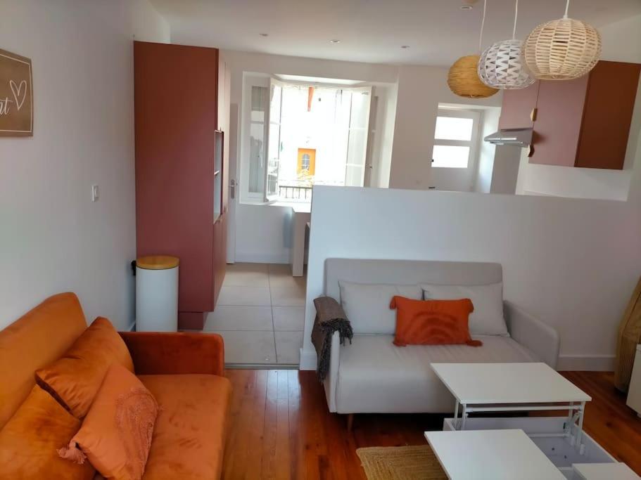 a living room with a couch and a table at Logement meublé au calme in Vertrieu