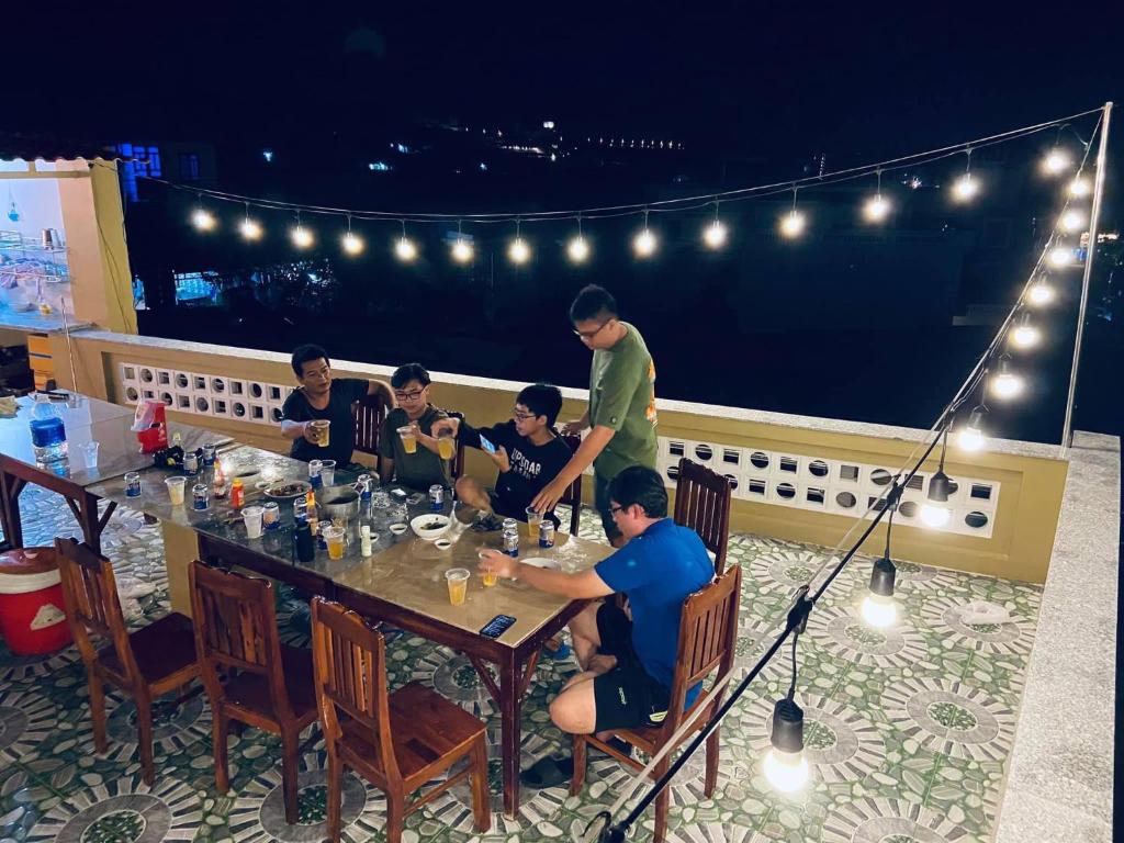 a group of people sitting at a table on a balcony at T'H Homestay in Mui Ne