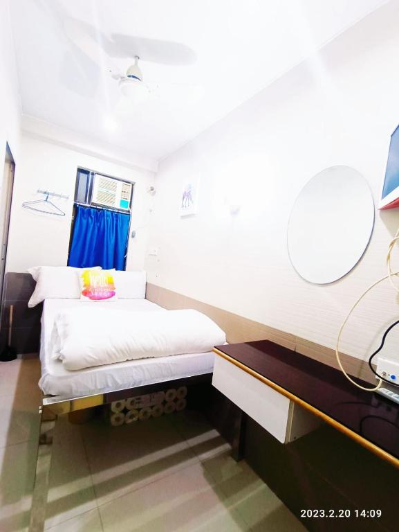 una piccola camera da letto con un letto e una scrivania di Apple Hostel 蘋果賓館 a Hong Kong