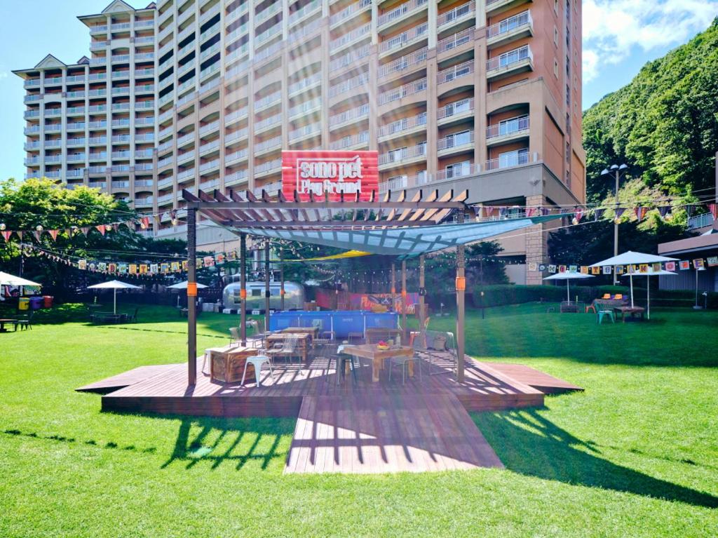 a picnic shelter in a park in front of a large building at Sono Pet Clubs & Resorts Vivaldi Park in Hongcheon