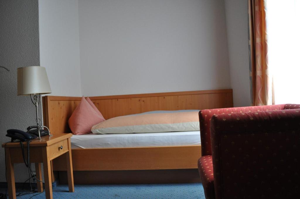 a bedroom with a bed and a table with a lamp at Hotel Engelberg "mein Trail Hotel" in Engelberg