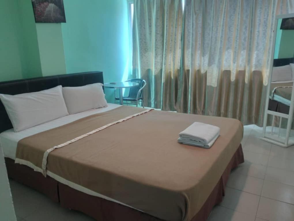 a large bed in a room with a large window at Best One Hotel in Melaka
