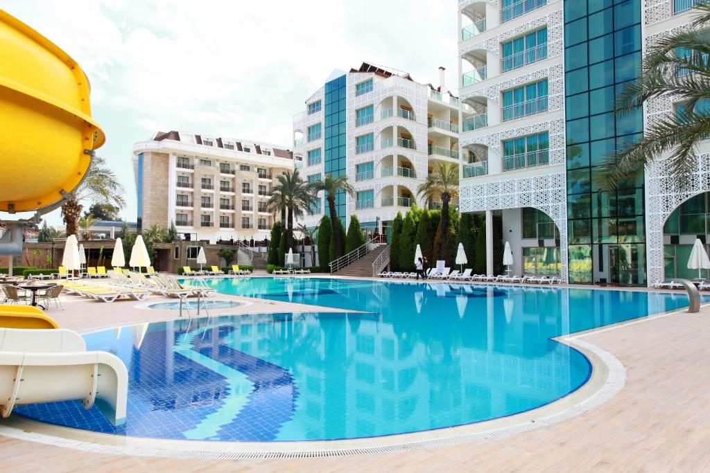 a swimming pool in a hotel with buildings in the background at Grand Ring Hotel in Beldibi