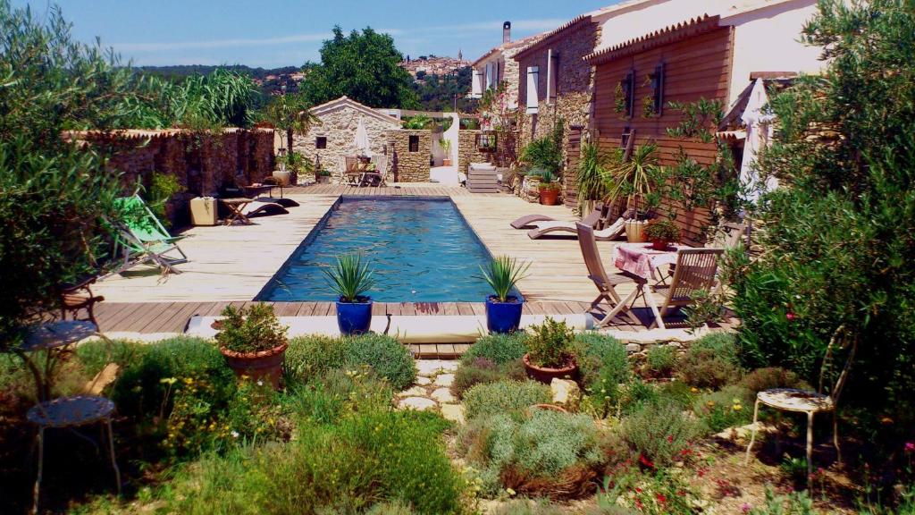 una piscina en un jardín con plantas en La Bastide des Sources, en Le Castellet