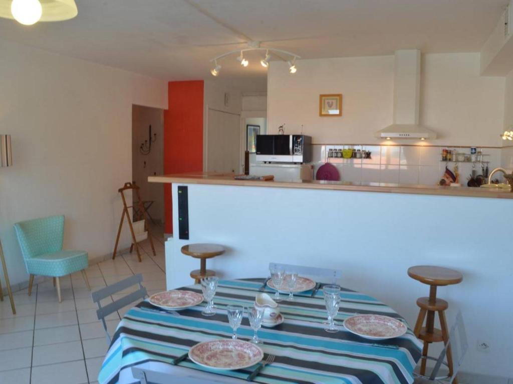 - une table avec des assiettes dans la cuisine dans l'établissement Appartement RDC avec Parking, 500m Port, Thalasso, 2 Chambres, 3 Étoiles, 4 Couchages - Banyuls-sur-Mer - FR-1-225C-589, à Banyuls-sur-Mer