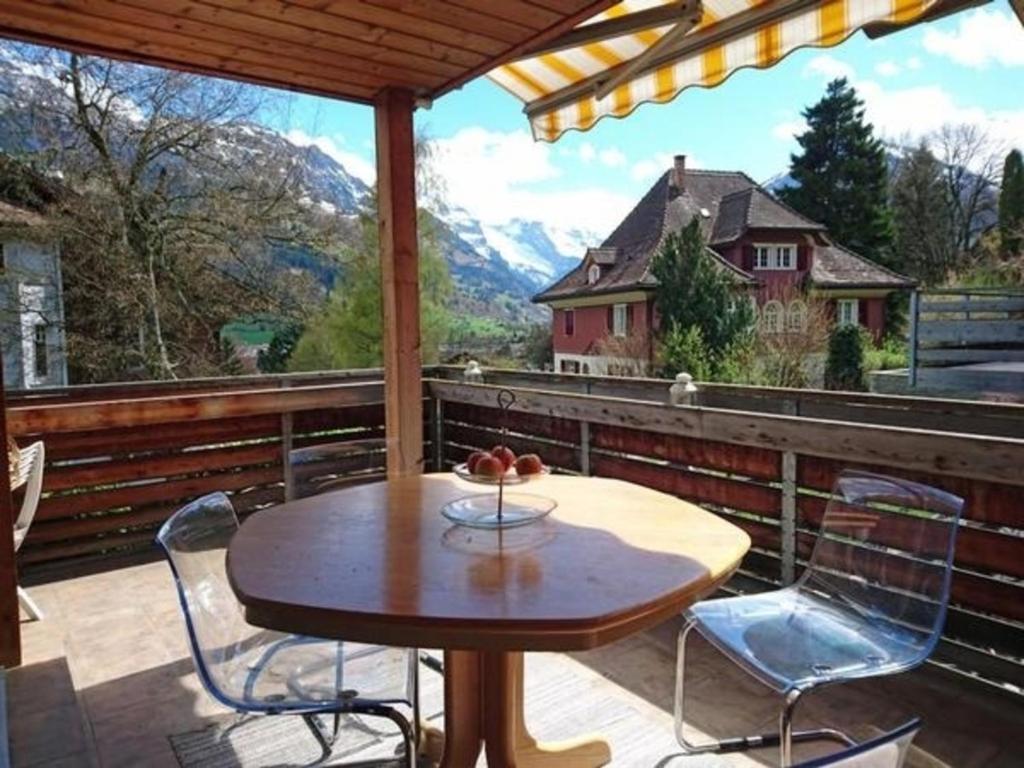 a table and chairs on a balcony with a view at Ferienwohnung Mänimatte in Frutigen
