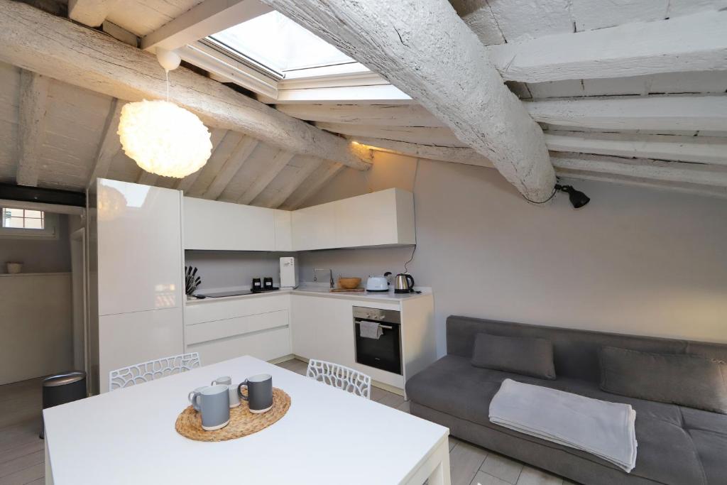 uma cozinha e sala de estar com uma mesa e um sofá em Loggia del Tenore Suite em Módena