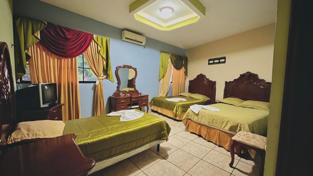 a hotel room with two beds and a tv at HOTEL CUNA MAYA B y B in Copan Ruinas