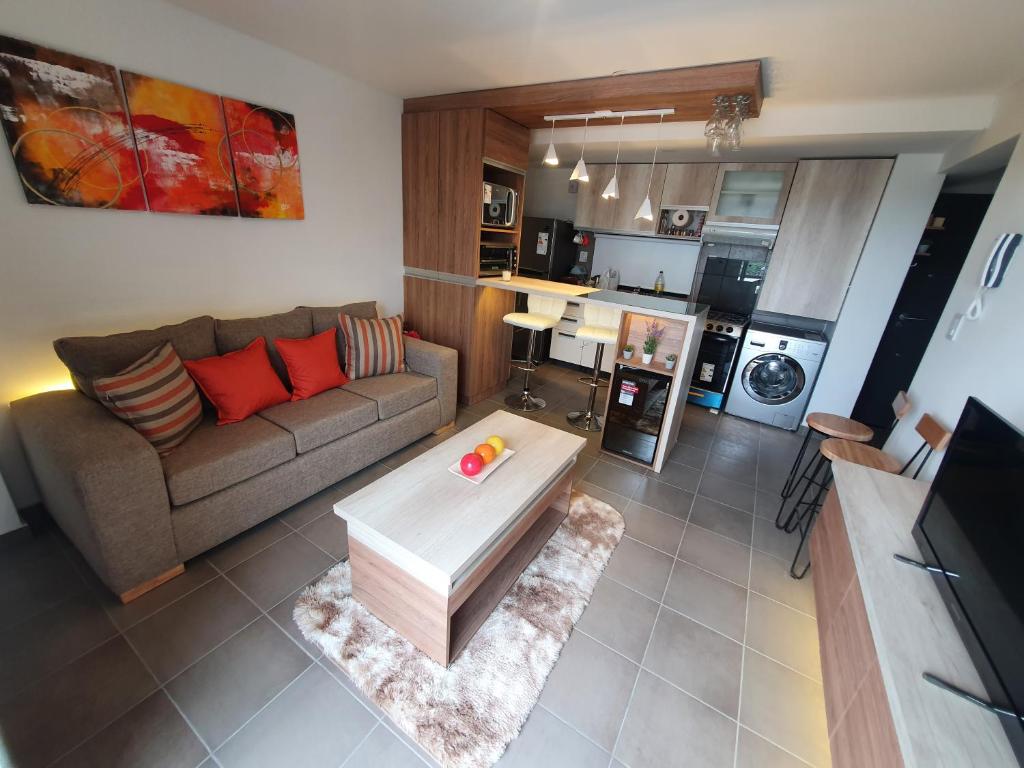 a living room with a couch and a table at Acogedor Departamento Vista a Cordillera in Godoy Cruz