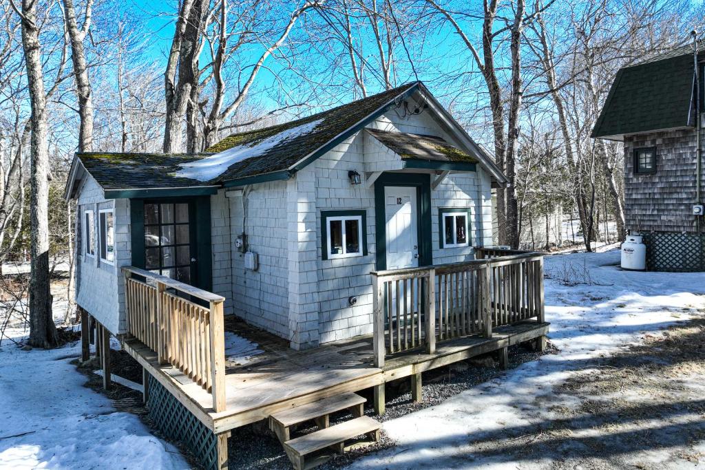 una pequeña casa con terraza en la nieve en Davis Cabin en Otter Creek