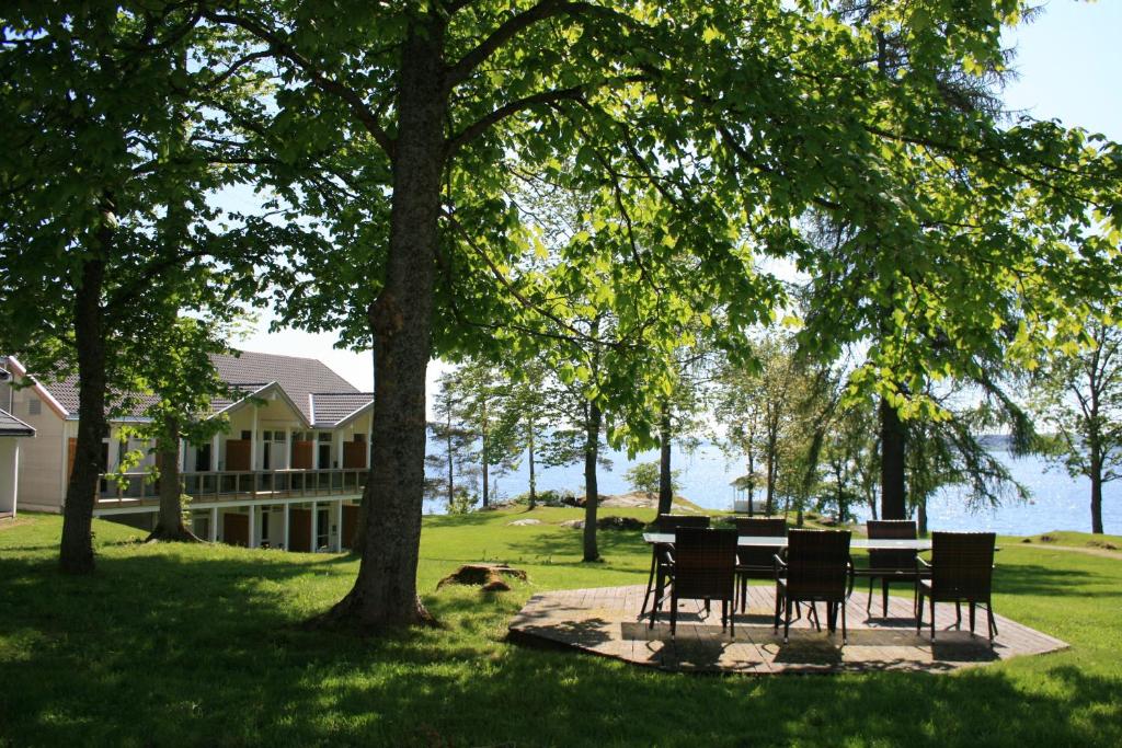 une table et des chaises sous un arbre à côté d'une maison dans l'établissement Jegtvolden Fjordhotell, à Straumen