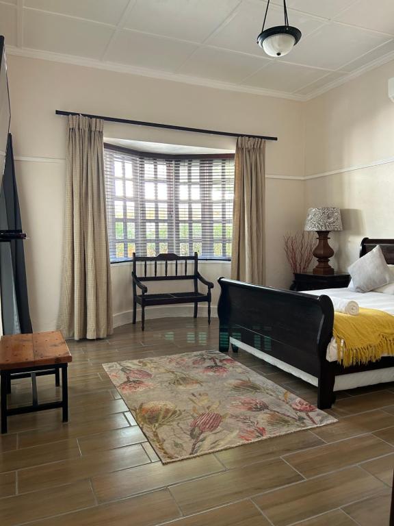 a bedroom with a bed and a large window at The Solomon Guest House in Kimberley