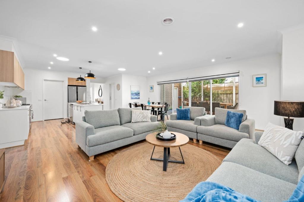 a living room with two couches and a table at Aerial Beach House - Beach & Golf in Torquay