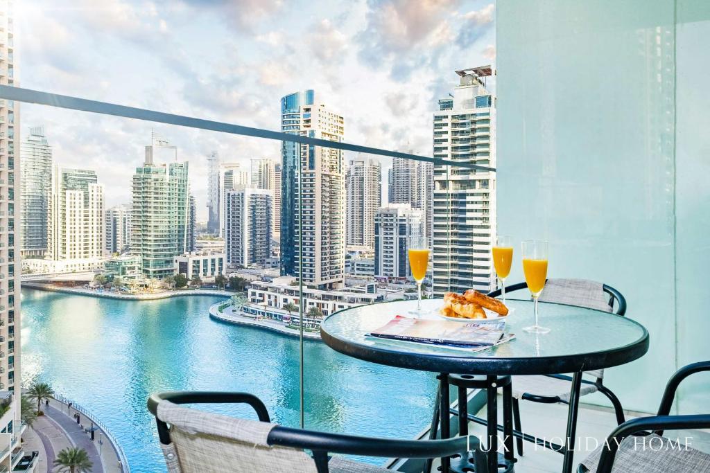 einen Balkon mit einem Tisch und 2 Gläsern Wein in der Unterkunft LUX Contemporary Suite with Full Marina View 6 in Dubai