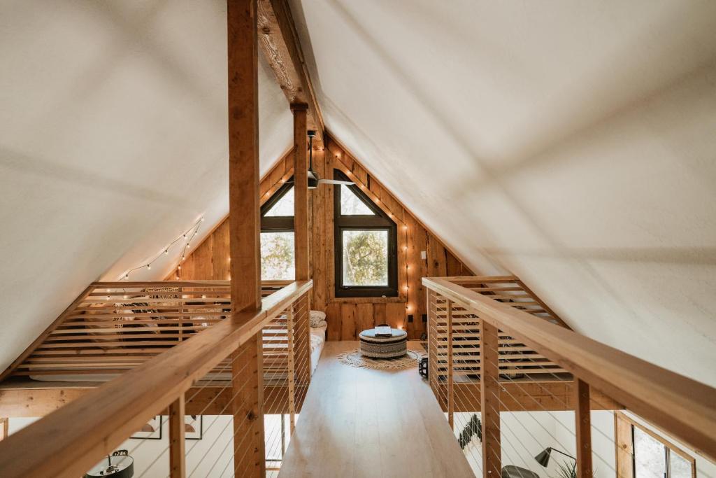Cette chambre dispose d'un escalier en bois et d'une fenêtre. dans l'établissement Lovers nest by Casa Oso with private hiking trails and pond, à Mariposa