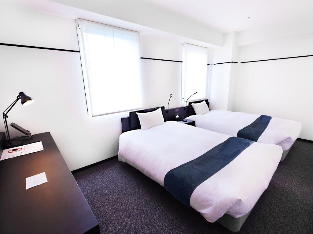 Postel nebo postele na pokoji v ubytování HOTEL SUI KANDA by ABEST